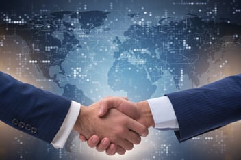 Handshake with a world map background representing global data