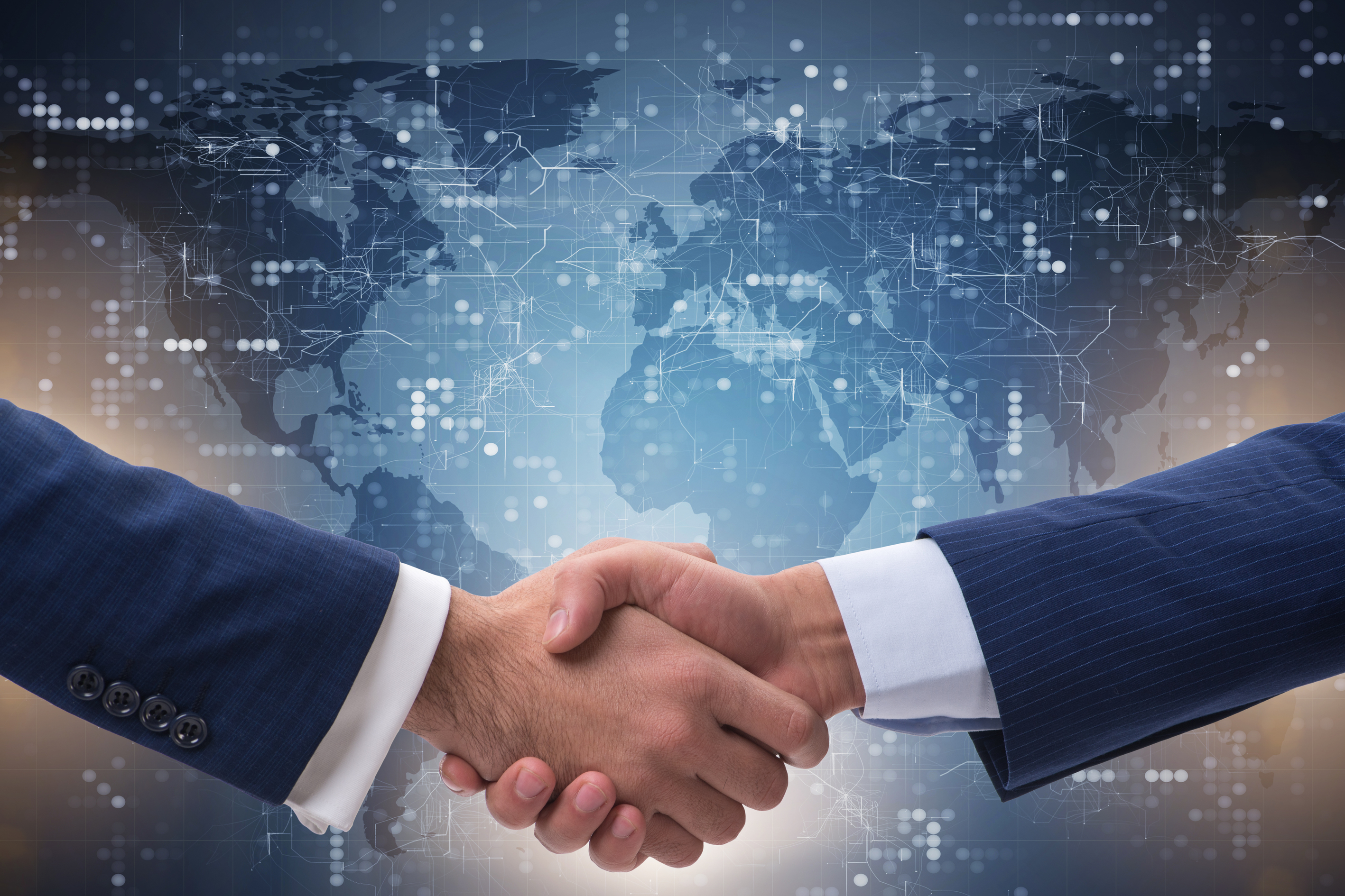 Handshake with a world map background representing global data